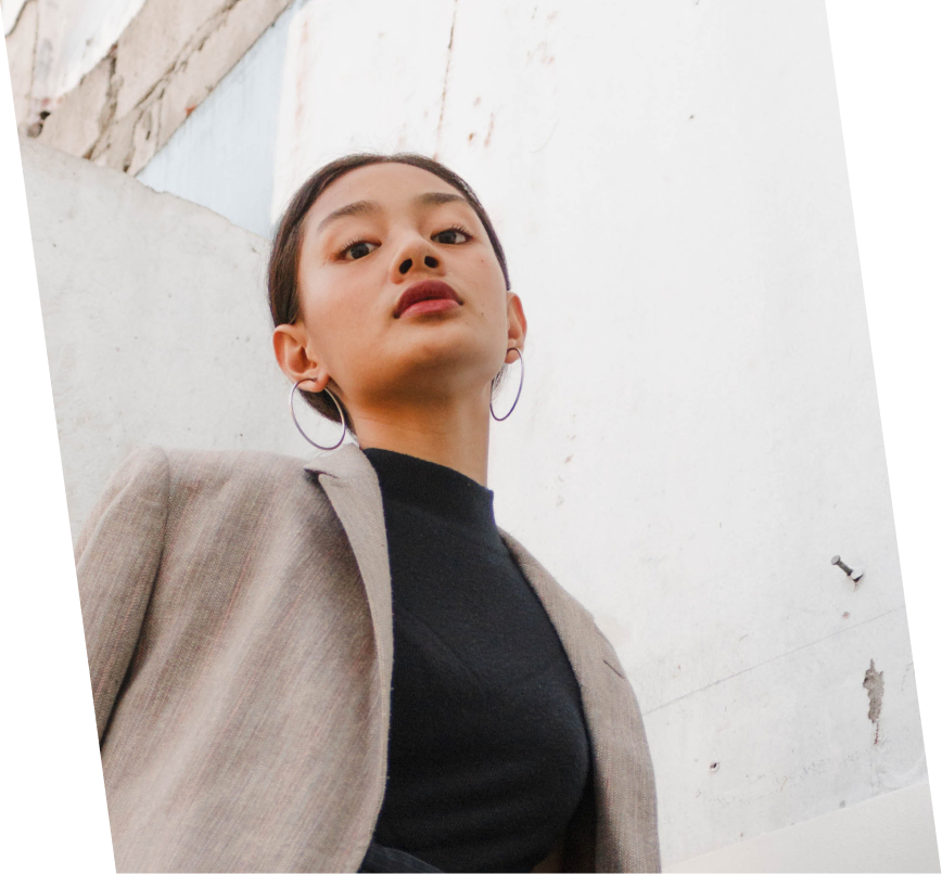 Person posing in front of concrete wall